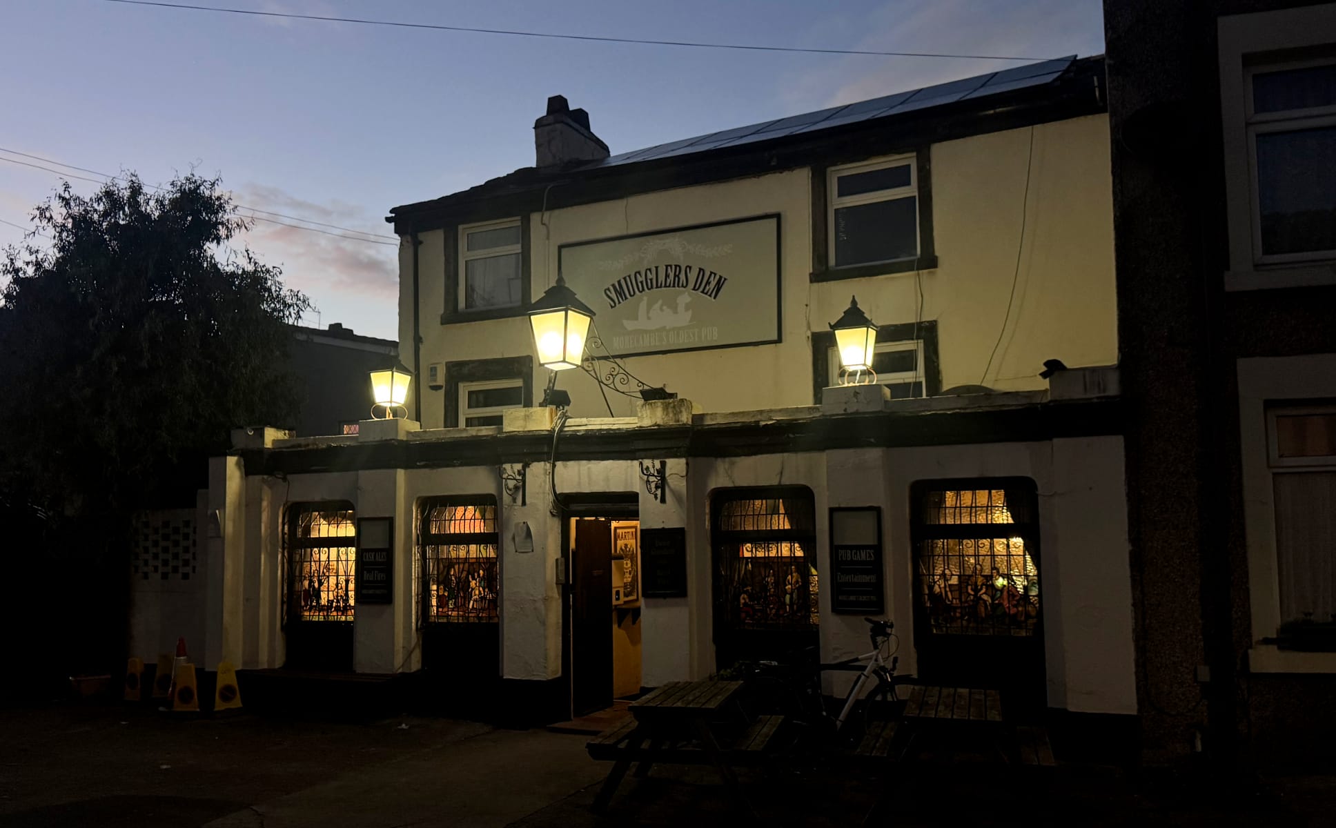 An old looking pub called The Smuggler's Den at dusk