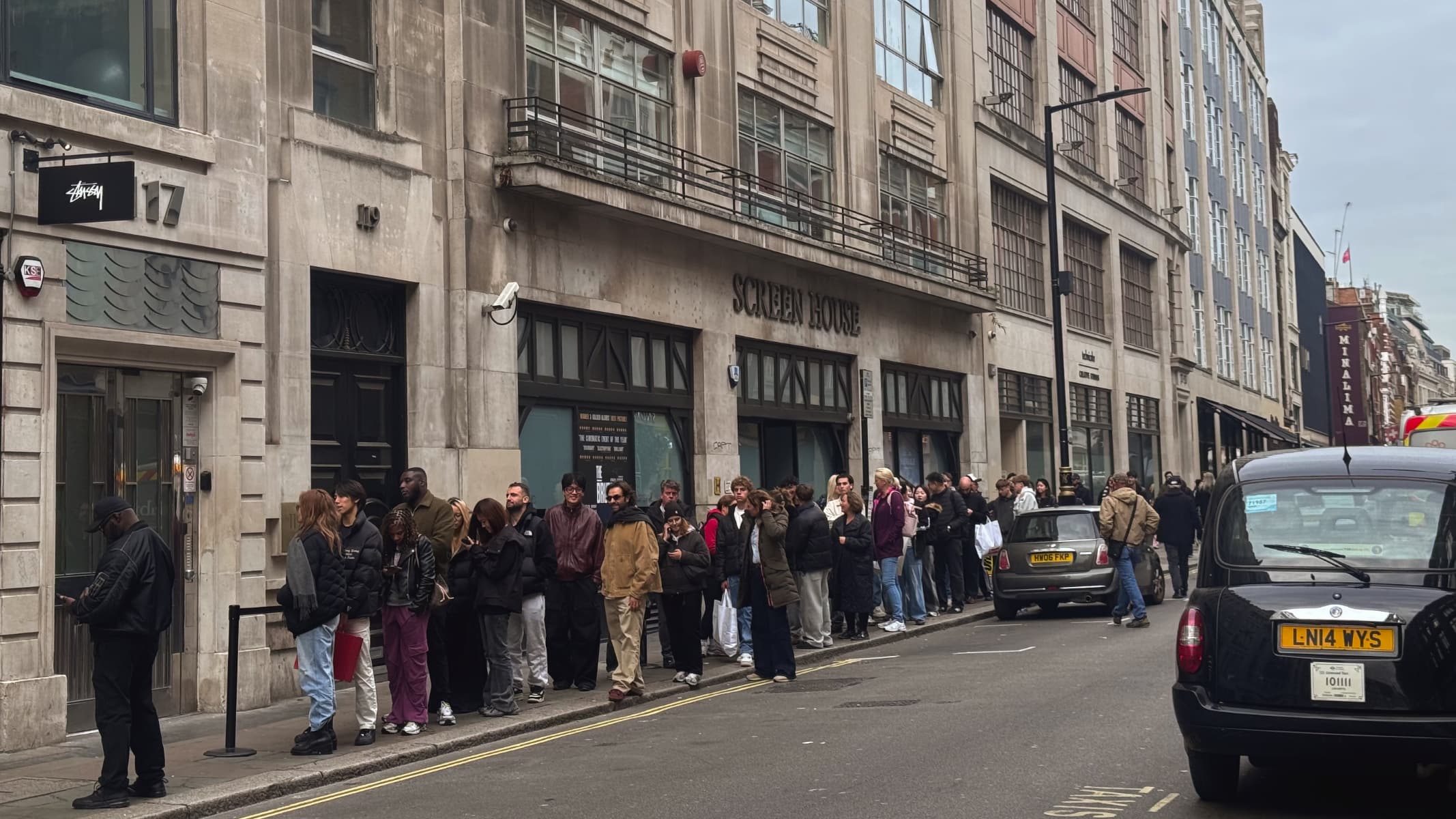 A queue of stylish young people on Wardour Street, Soho