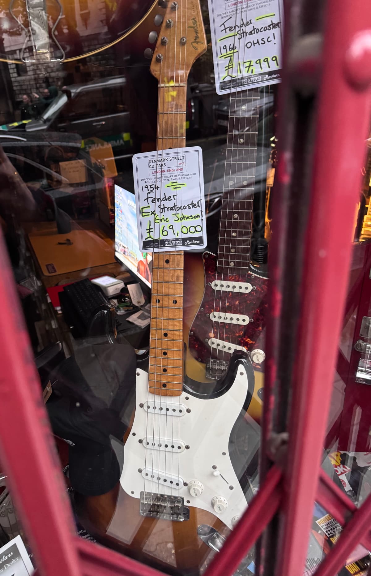 A window display of a 1954 Fender Stratocaster with a tag that notes Ex-Eric Johnson and a price of £69,999