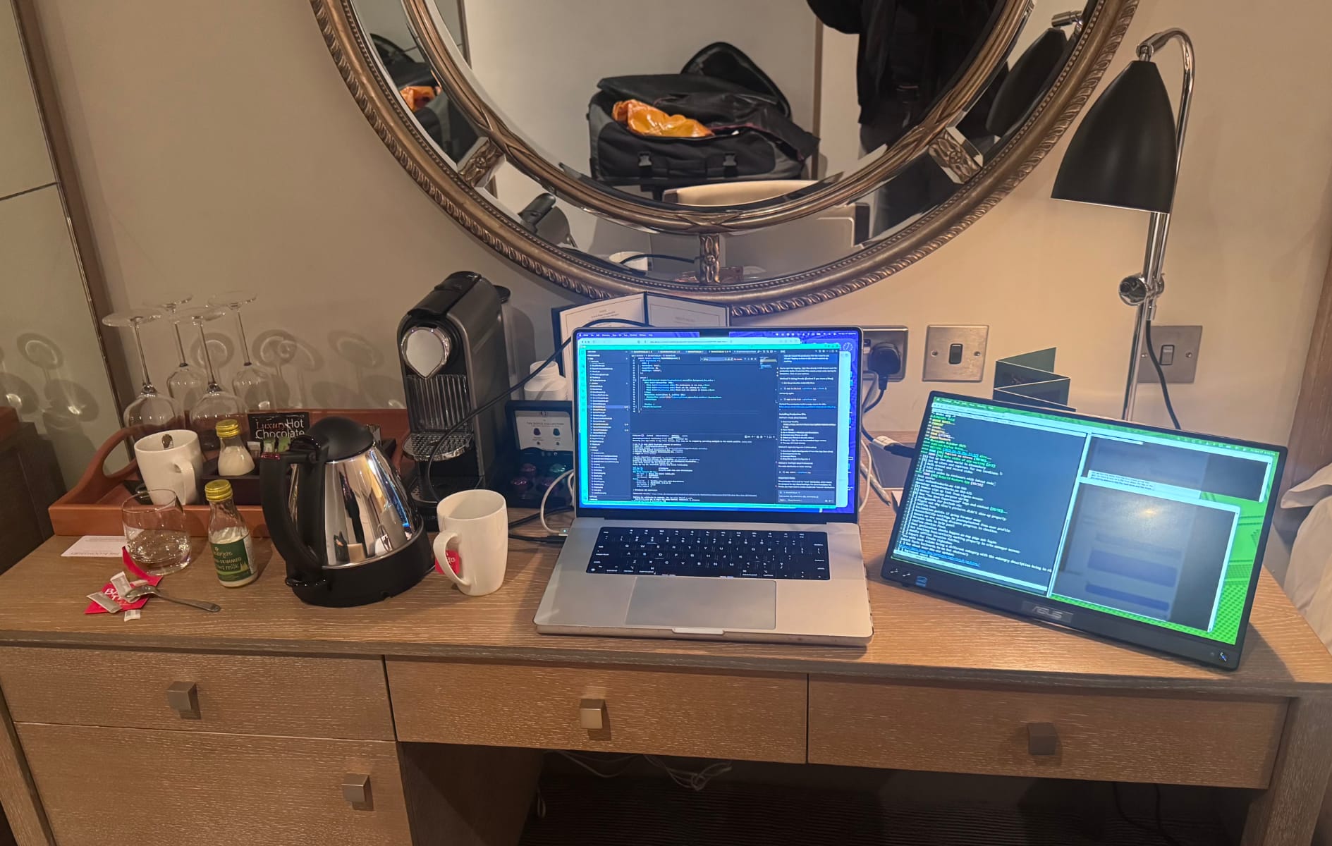 A MacBook Pro M1 and an ASUS portable display on a hotel desk