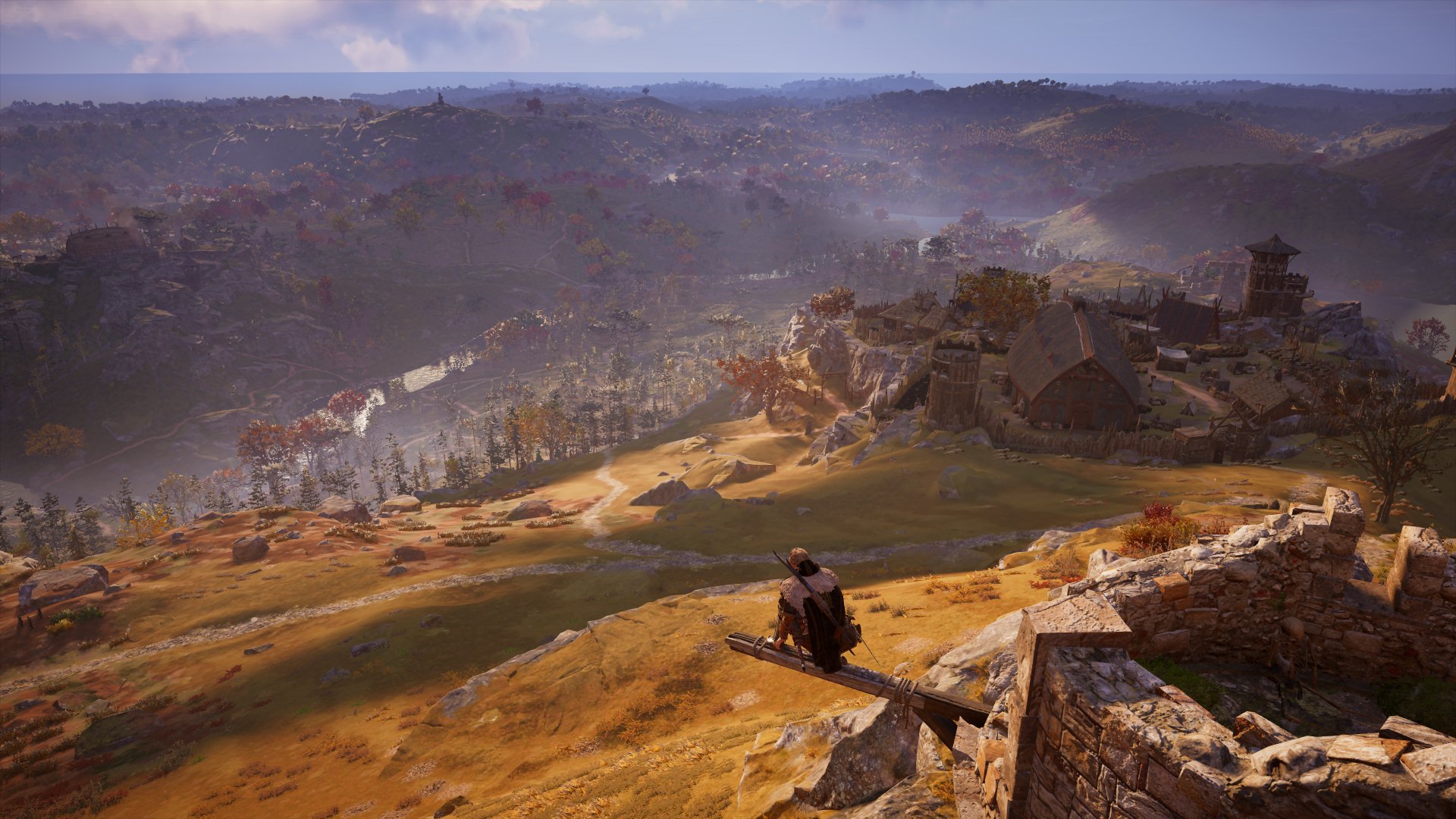 A 'synchronize' scene at a Fast Travel point in Assassin's Creed Valhalla, among rolling hills of Britain.
