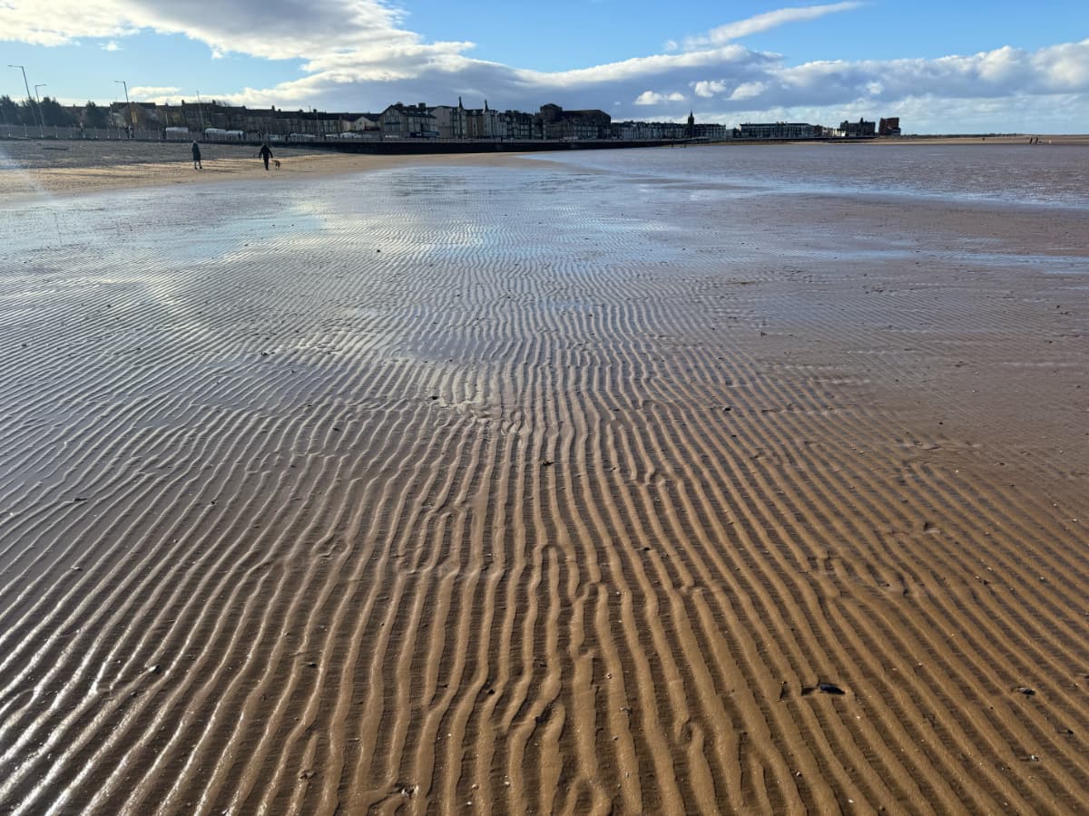 Wavy sands in Morecambe Bay leading to the town and Promenade