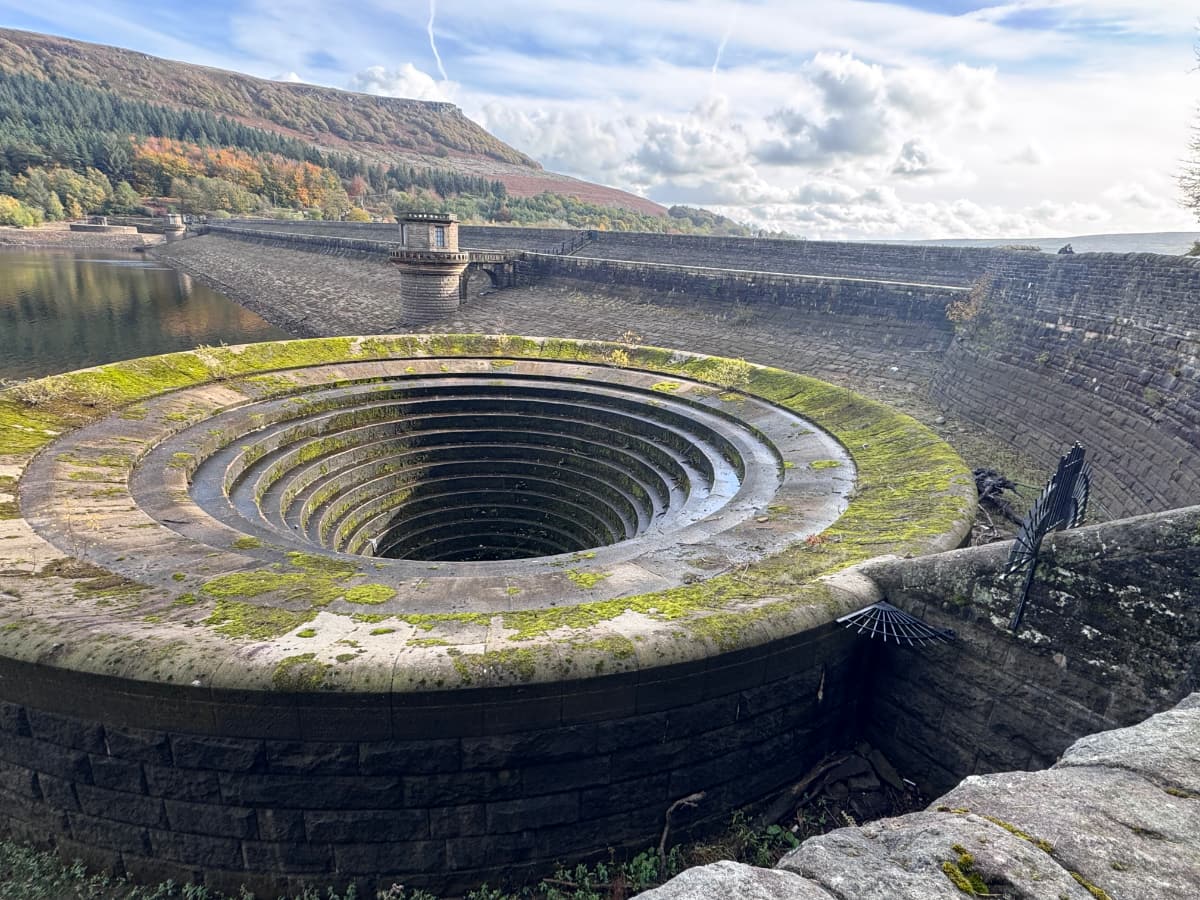 A large stone 'plughole' of concentric stone circles by a large dam in the Peak District